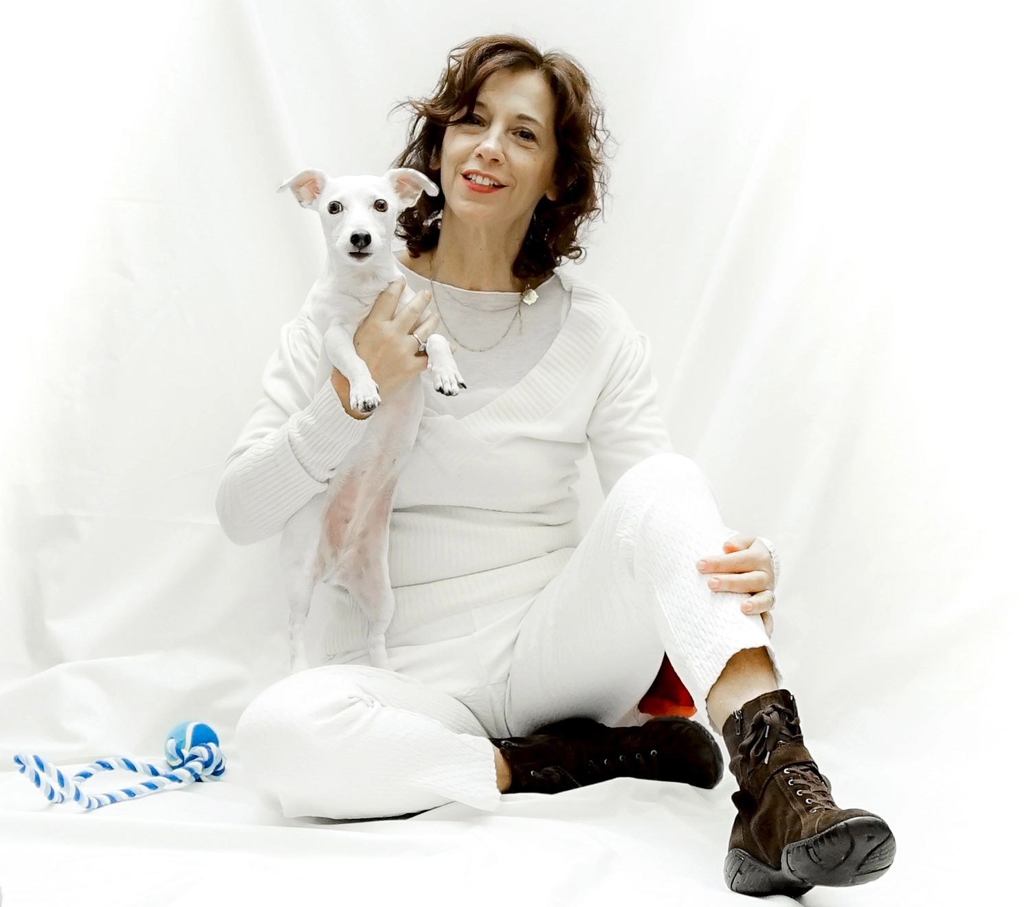 02_Claudia_Giunta Donna vestita di bianco Dog Trainer che ha in braccio un cane